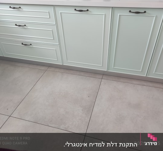 ארונות מטבח עם ידיות כהות ורצפת אריחים אפורה